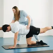 Fisioterapeuta orientando prescrição de exercício em ambiente clínico moderno
