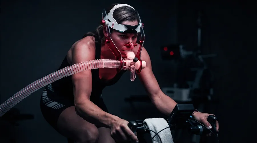 Zona 2 e VO₂máx — ciclista em teste ergoespirométrico com máscara respiratória